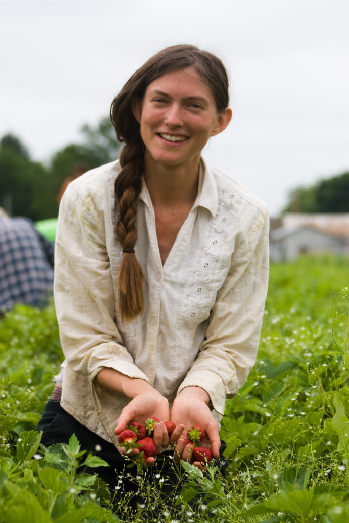 farmer Sarah Voiland with strawberries in field